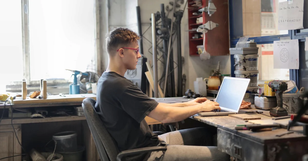 Técnico de TI estudiando frente a una laptop con íconos de seguridad y candados en pantalla