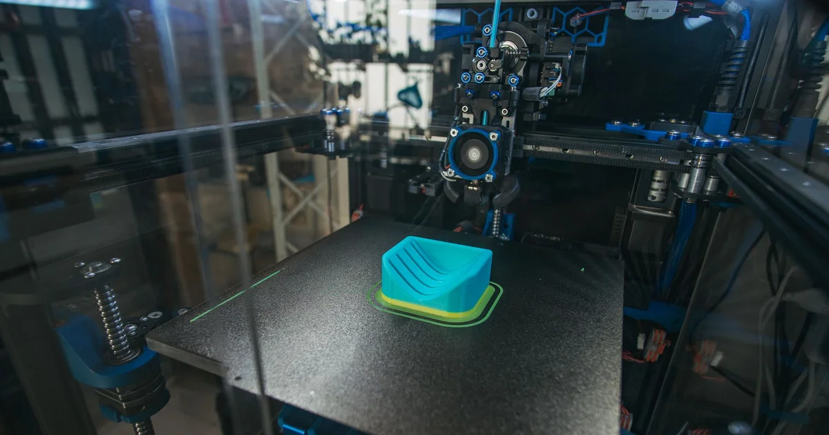 Close-up of a 3D printer producing a plastic part in an industrial setting