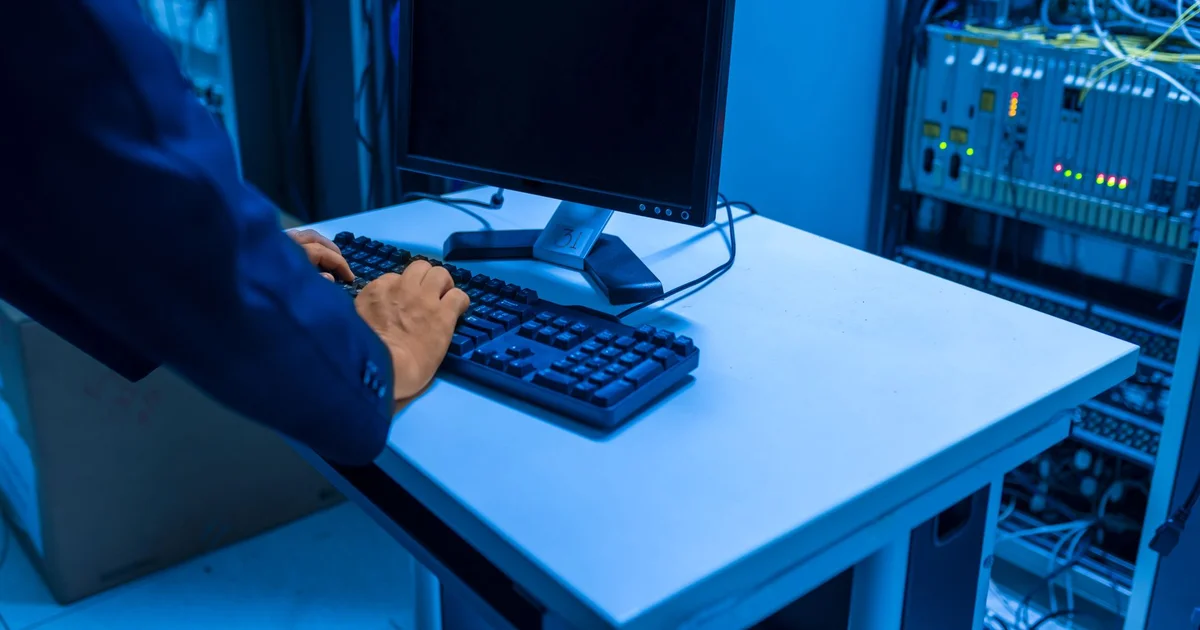 Equipo de TI revisando servidores y pantallas de migración de datos en una oficina